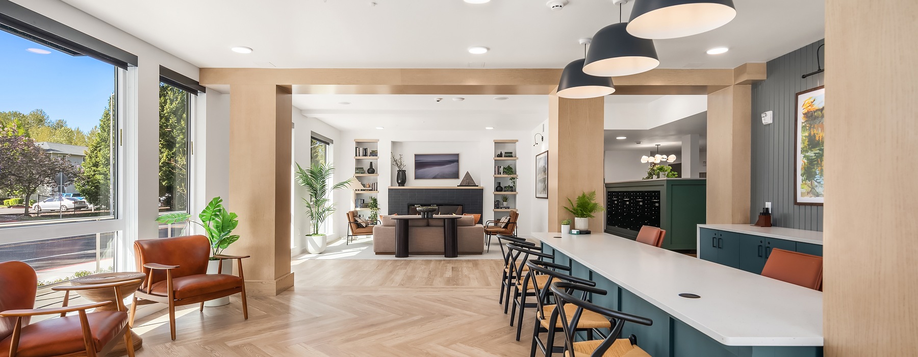 Resident lounge at our apartments for rent in Kent, WA, featuring wood grain floor paneling and counter seating.